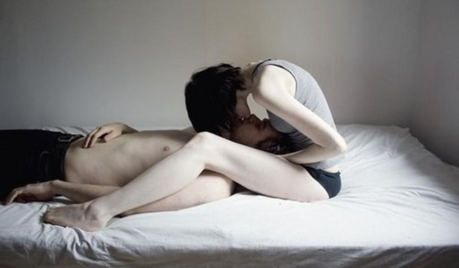 Мужчина целует женщину в кровати фото