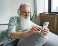 Пенсіонер користується мобільним телефоном, обираючи вигідний тариф