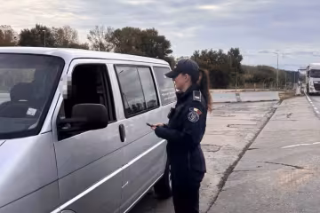 Пограничница проверяет документы у водителя на границе