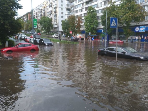 У Києві авто затягує в ями після руйнівної зливи: кадри курйозної ДТП