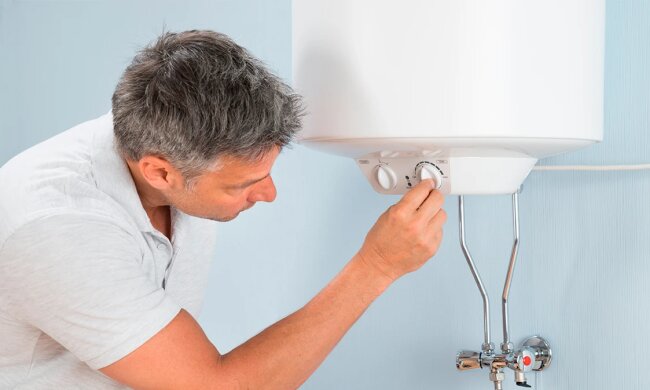 Чоловік вмикає бойлер