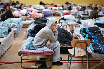 Дівчинка сидить в центрі для біженців