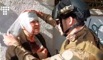 Військовий перев'язує голову бабусі, кадр з відео