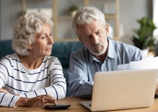 Пенсіонери, які сидять перед ноутбуком