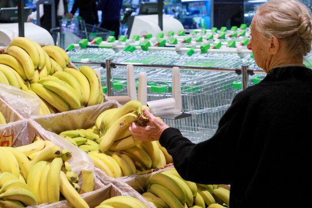 Женщина, выбирающая бананы