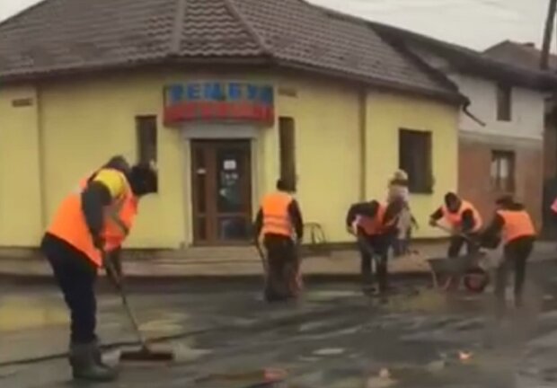 Коммунальщики убирают лужи лопатами, кадр из видео: Telegram "ХУкраина / Новости"