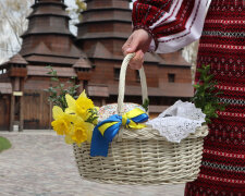 Жінка з великоднім кошиком біля храму