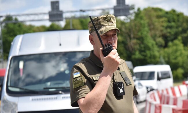 Пограничник на пункте пропуска проверяет документы