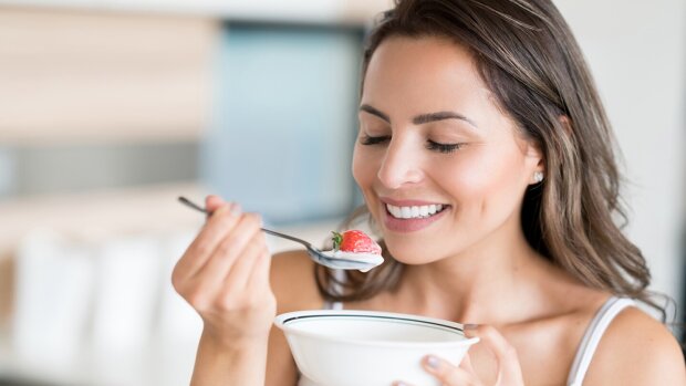 Жінка їсть йогурт