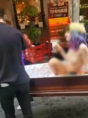 Обнаженную девушку носили в гробу, скриншот из видео