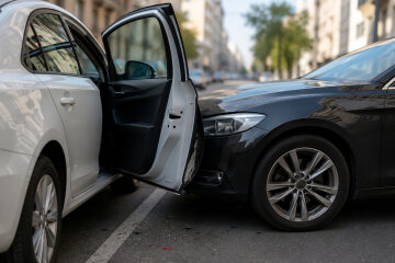 Відчинені двері авто на дорозі