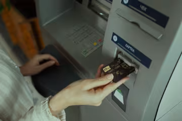 Людина, яка знімає гроші з банкомату