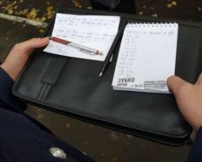 Біля дільниць в Києві ходять невідомі зі списками виборців (фото)