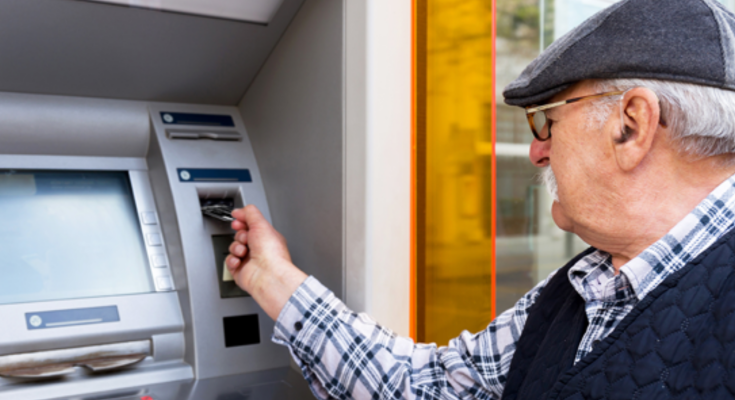 Пенсіонер, який знимає кошти з банкомату