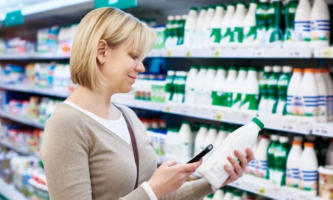 Женщина, держащая кефир в супермаркете