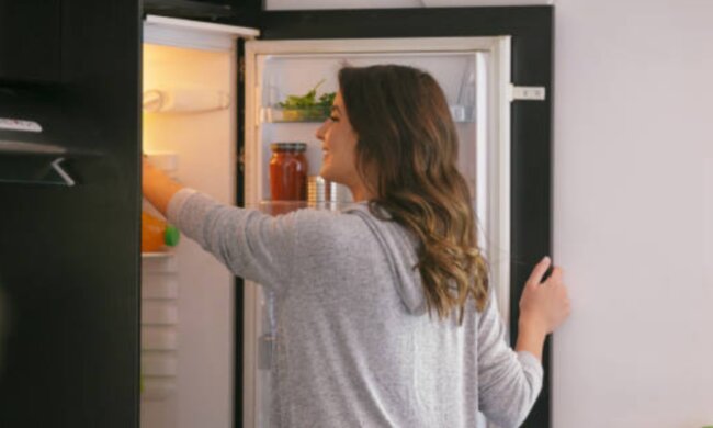 Жінка, яка лізе до холодильника