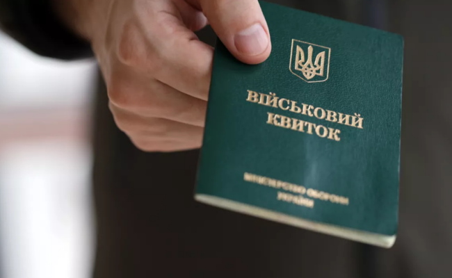 Человек, держащий военный билет в руке