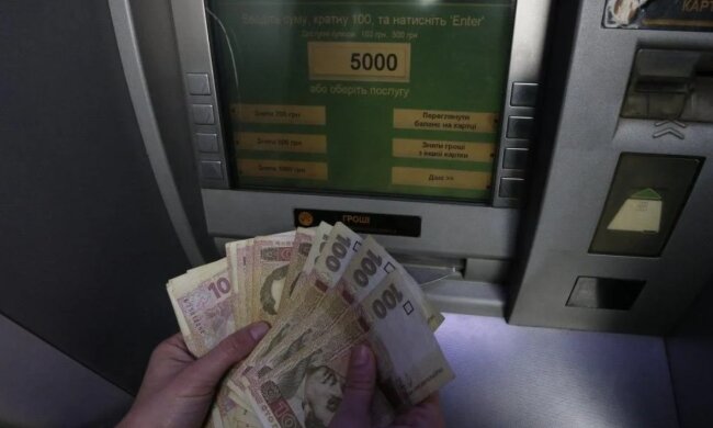 Человек снимает наличные в банкомате. Фото: bbc