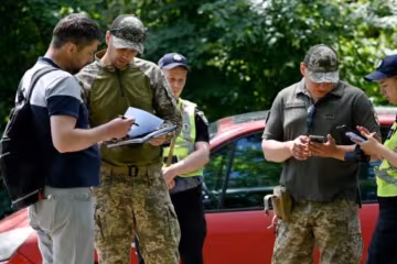 Працівники ТЦК перевіряють чоловіка. Фото: youtube