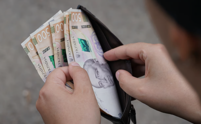 Человек, держащий кошелек с деньгами