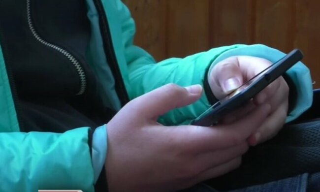 дитина тримає телефон, ілюстративне фото з вільних джерел