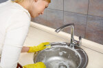 Женщина чистит раковину