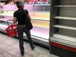 Жінка стоїть біля прилавків