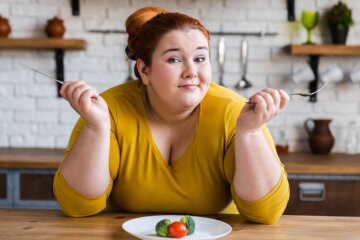 Жінка з зайвою вагою і продукти на тарілці
