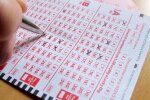 Людина, яка закреслює номери в лотерейному квитку