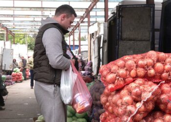 Мужчина на рынке возле лука