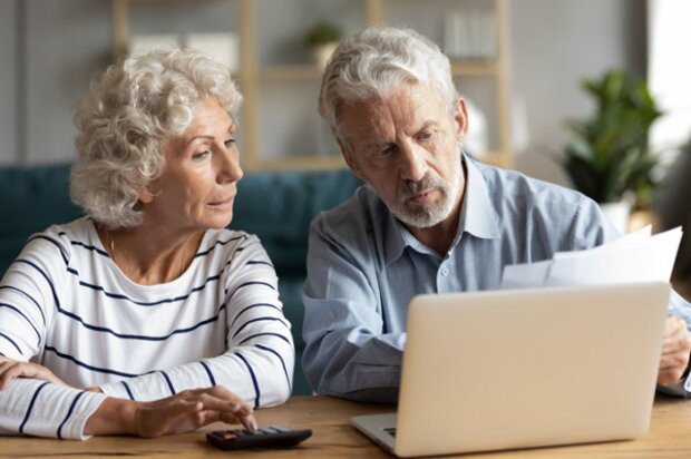 Пенсионеры, сидящие перед ноутбуком