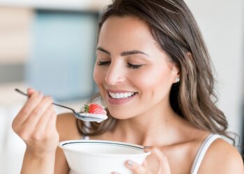 Жінка їсть йогурт