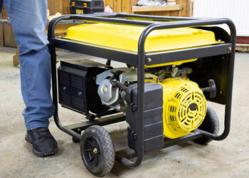 Мужчина стоит возле генератора