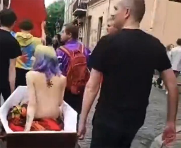 Обнаженную девушку носили в гробу, скриншот из видео