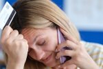 Женщина разговаривает по телефону и держит карту в руках.