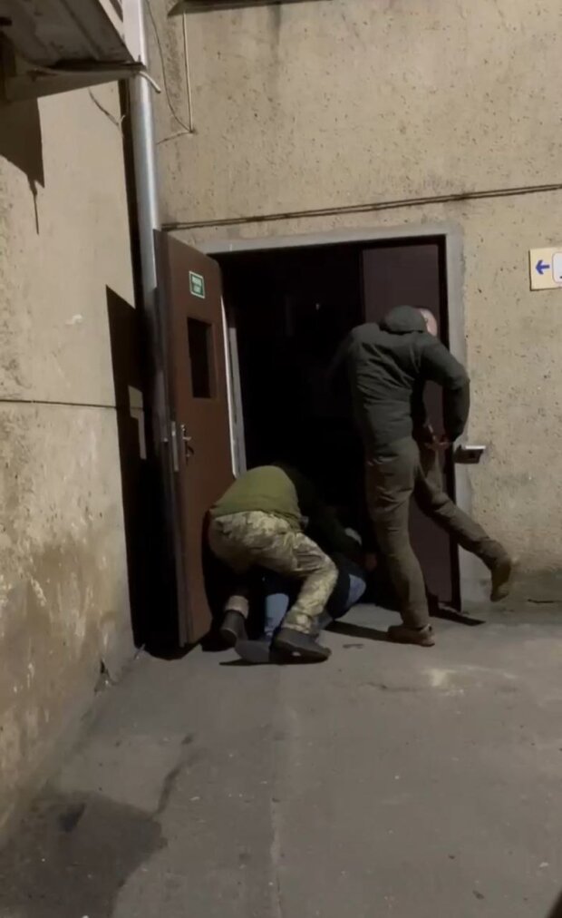 Чоловіка силоміць затягують до ТЦК. Фото: скрін відео