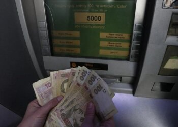 Человек снимает наличные в банкомате. Фото: bbc