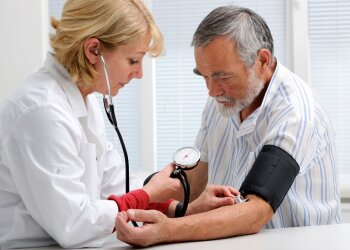 Врач меряет давление пациенту