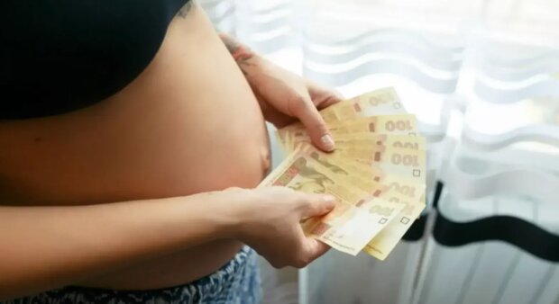 Беременная женщина с деньгами в руках. Фото: Freepik