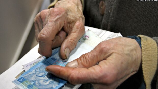 Пенсионер держит деньги в руках