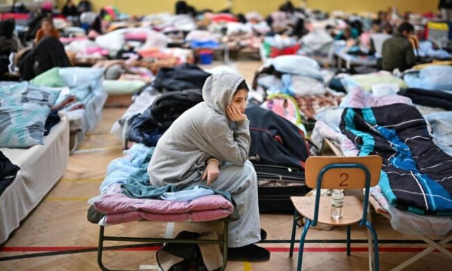 Девочка сидит в центре для беженцев
