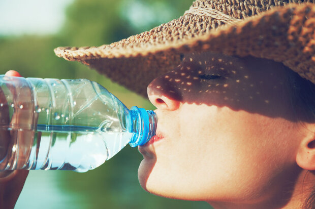 Женщина, пьющая воду в жару