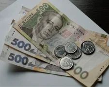 Пенсіонер із гривнями в руках