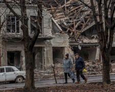 Люди на фоне разрушенного города / фото: CNN