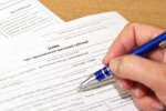 Людина заповнює заяву про призначення субсидій