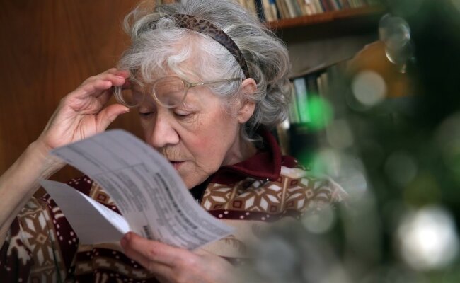 Бабушка читает платежку за коммуналку, Российская газета