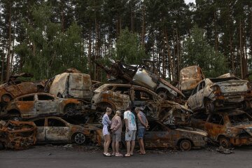 Люди біля своєї зруйнованої автівки