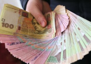 Людина, яка тримає гроші в руке