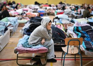 Девочка сидит в центре для беженцев