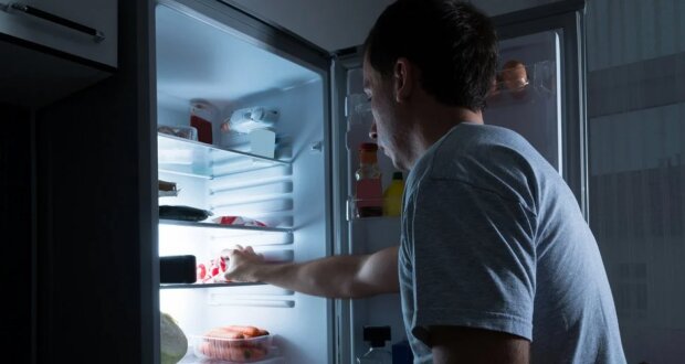 Мужчина, который лезет в холодильник